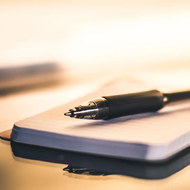 A ballpoint pen resting on a closed notebook