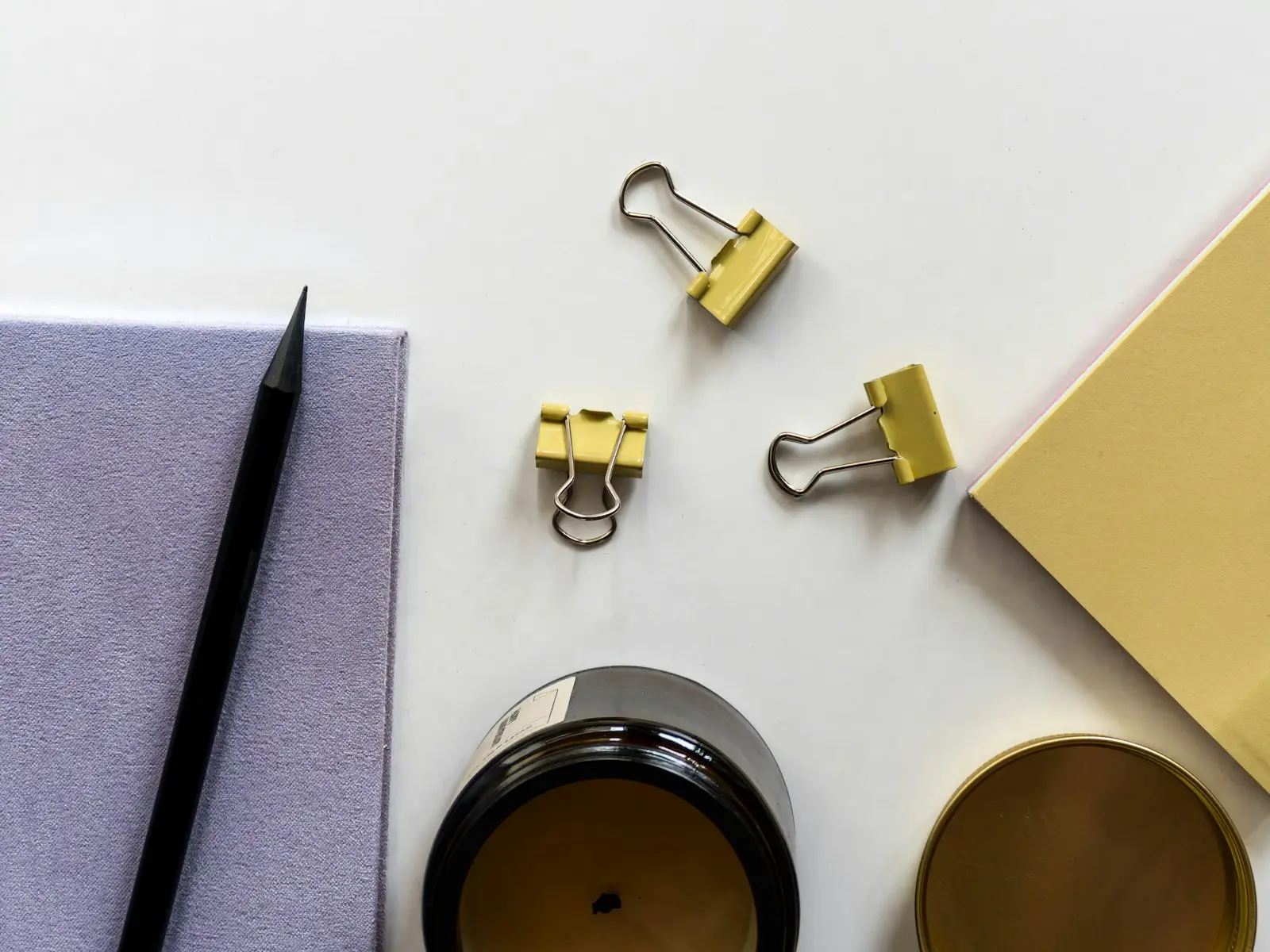 A notebook, pen and desk accessories arranged on a pale surface