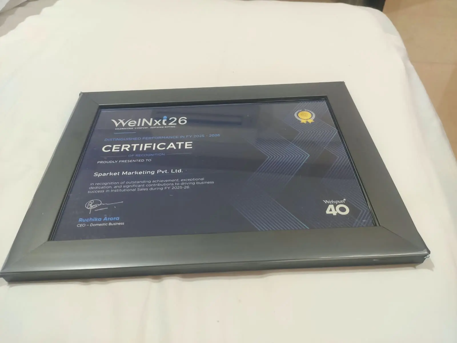 Framed Welspun WelNxt 26 Certificate of Recognition presented to Sparket Marketing Pvt. Ltd.