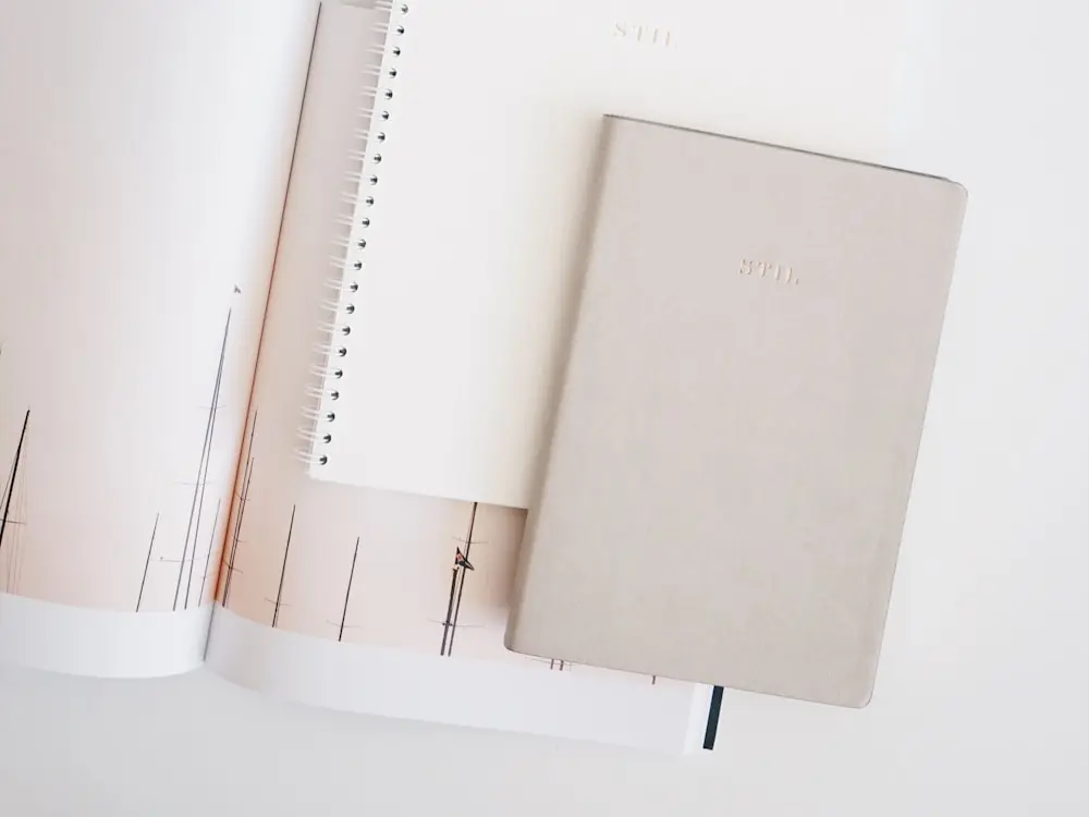 Two branded notebooks on a light desk