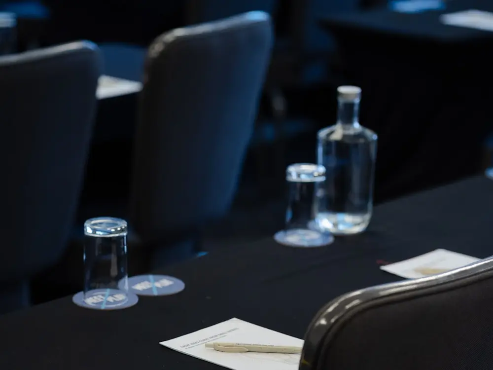 A conference table set with notepads and water